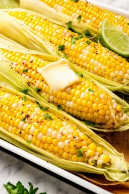 Microwave corn on the cob with pat of butter and lime wedge.