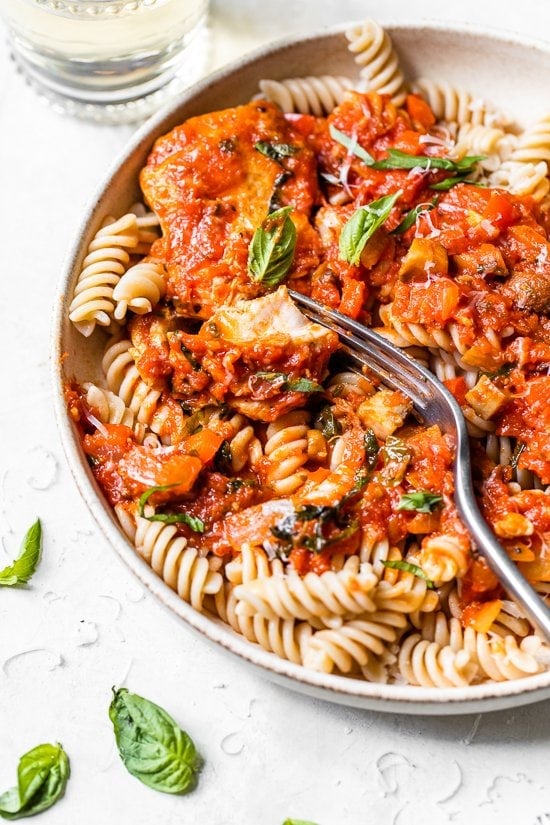 Chicken cacciatore is a rustic Italian chicken dish made with bell peppers and mushrooms slow-simmered in a rich tomato sauce with herbs. Homemade Italian chicken cacciatore served over pasta.