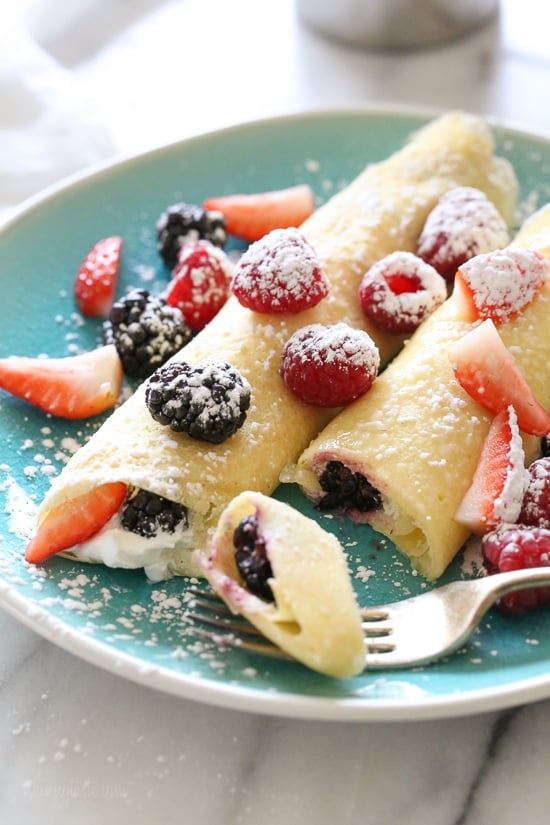 With just 4 main ingredients and everything prepared in the blend, this Easy Crepes Recipe is virtually foolproof! A fork cutting off a piece of crepe