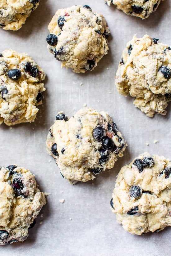 Blueberry scones ready to bake, on a baking sheet.