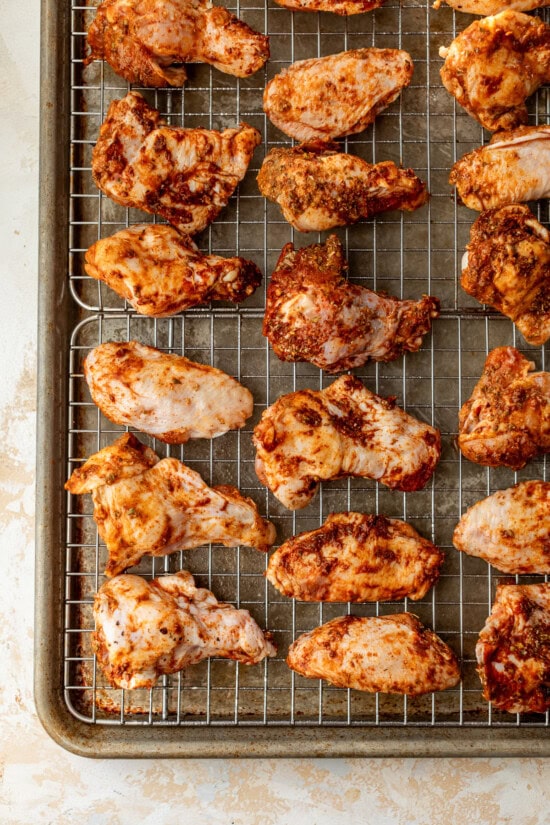 These homemade buffalo wings will be the hit at your next football party! They're baked in the oven and so much lighter than deep-fried. Broiled chicken wings on wire racks set on top of baking sheets.