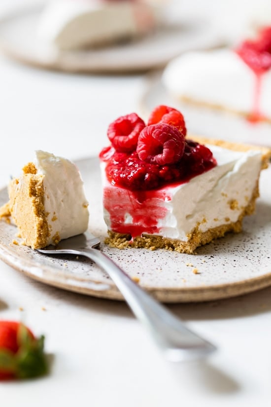 This easy no-bake cheesecake is light, dreamy and so easy to make, you don’t even need an oven. A little slice of heaven! No-bake cheesecake slice on plate with tip of cake on fork