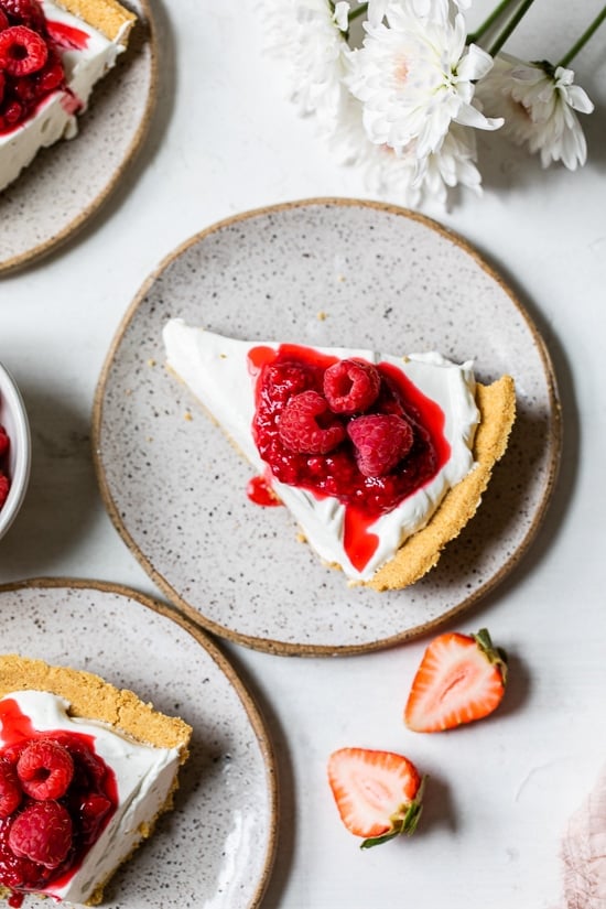 This easy no-bake cheesecake is light, dreamy and so easy to make, you don’t even need an oven. A little slice of heaven! Overhead view of no-bake cheesecake on plate topped with berries