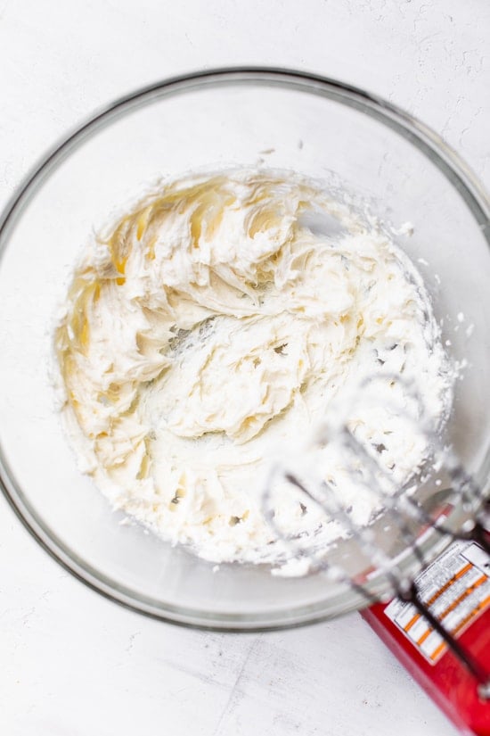 This easy no-bake cheesecake is light, dreamy and so easy to make, you don’t even need an oven. A little slice of heaven! Beating no-bake cheesecake filling in mixing bowl