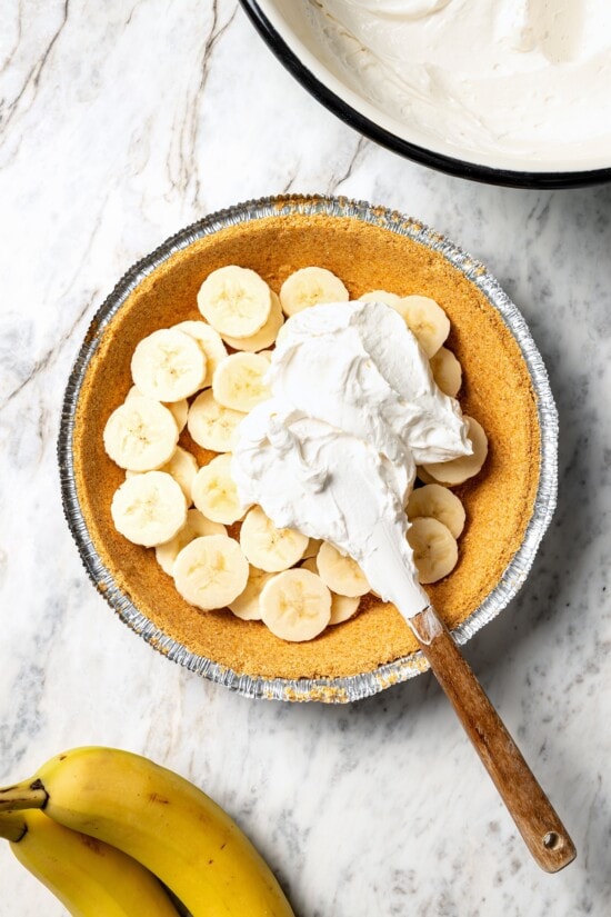 This easy banana cream pie recipe is creamy, fluffy, and full of fresh banana flavor. It’s a lighter take on a classic dessert! Adding banana cream pie filling to crust.