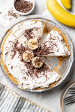 Overhead view of banana cream pie with one slice removed.