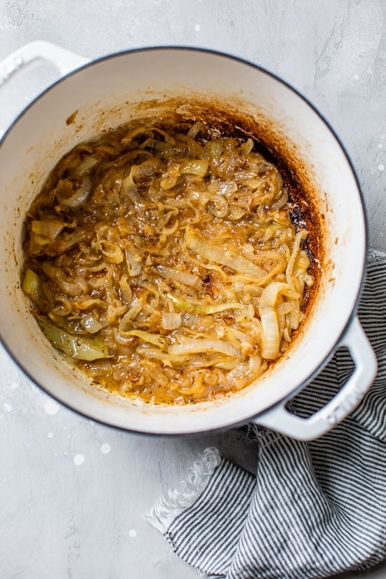 This lightened-up French onion soup recipe is just as delicious as the original, with beefy broth, caramelized onions, and melty cheese! Caramelized onions in a large pot.