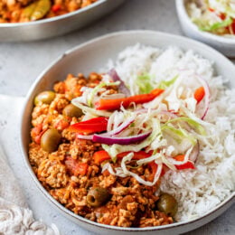 Turkey Picadillo with rice and slaw on a plate.