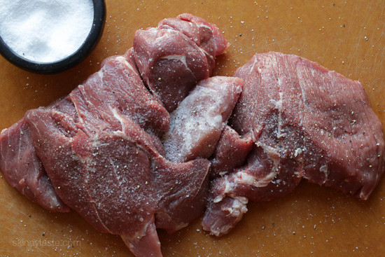 The best Instant Pot Carnitas recipe! Make juicy Mexican pulled pork in the pressure cooker for tacos, burrito bowls, taco salads, and more. Raw pork shoulder cut into four pieces and seasoned with salt on a countertop.