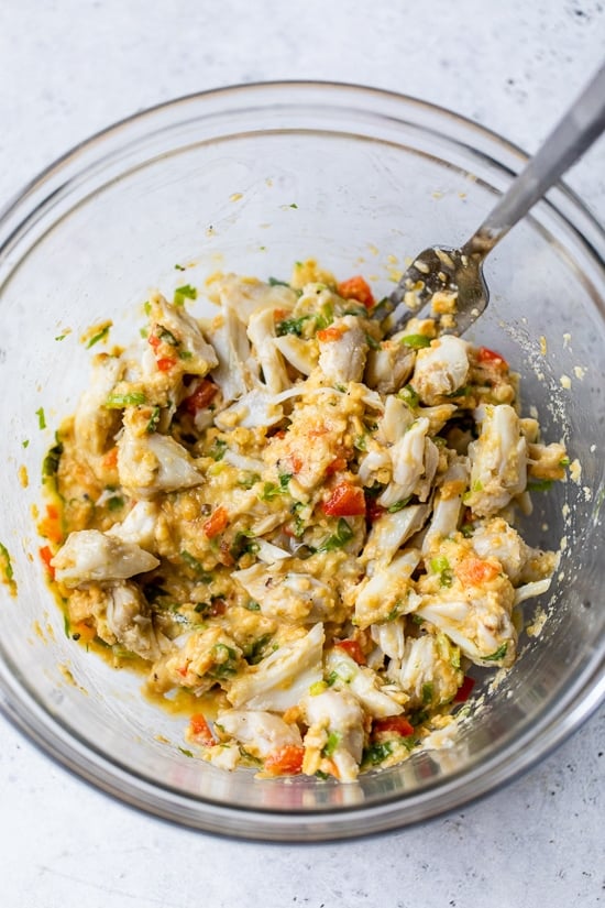 This easy baked crab cakes recipe combines juicy lump crab meat, simple seasonings, and fresh herbs. Perfect as an appetizer or light dinner! Crab cake ingredients combined in a bowl.