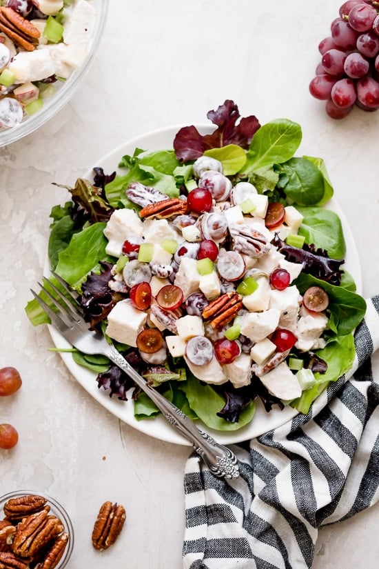 Plate of chicken Waldorf salad with fresh greens.