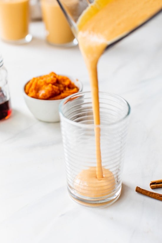 Made with Greek yogurt, pumpkin puree, and pumpkin pie spice, this Pumpkin Smoothie tastes just like a slice of pumpkin pie. Pumpkin Smoothie being poured into a glass