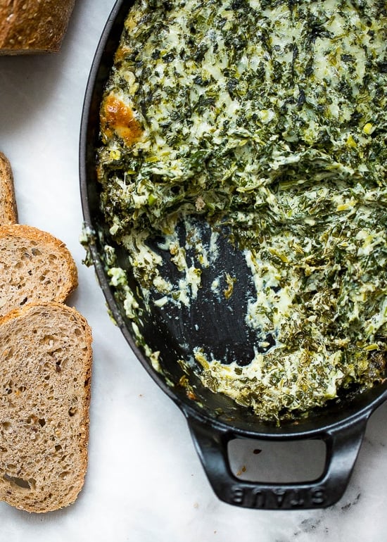 This cheesy hot spinach dip is perfect for parties! You can double or triple this lightened up recipe as needed and it’s always a hit. Cheesy hot spinach dip in baking dish