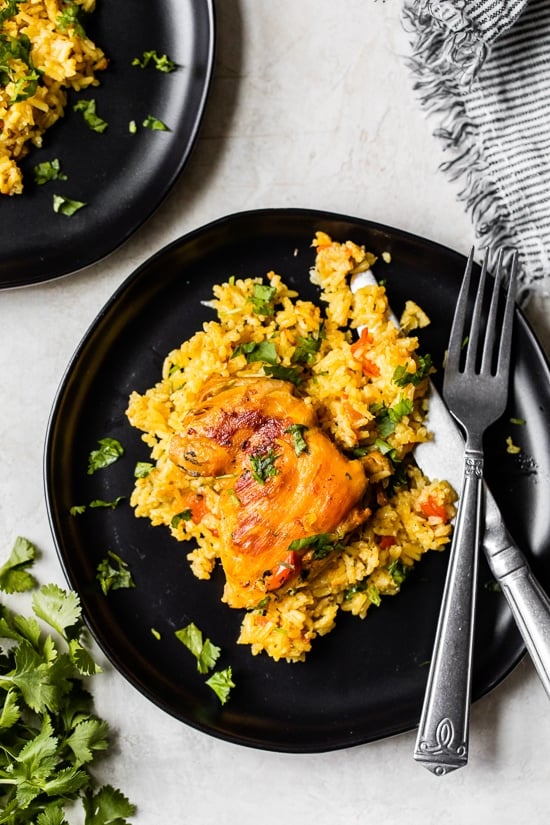 Authentic Arroz Con Pollo, or Latin chicken and rice, is the ultimate one-pot meal. It’s a classic Latin dish that I grew up with and love! Overhead view of Arroz con Pollo served on a plate.