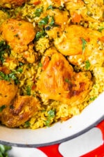 Overhead view of Arroz Con Pollo in a red Dutch oven.