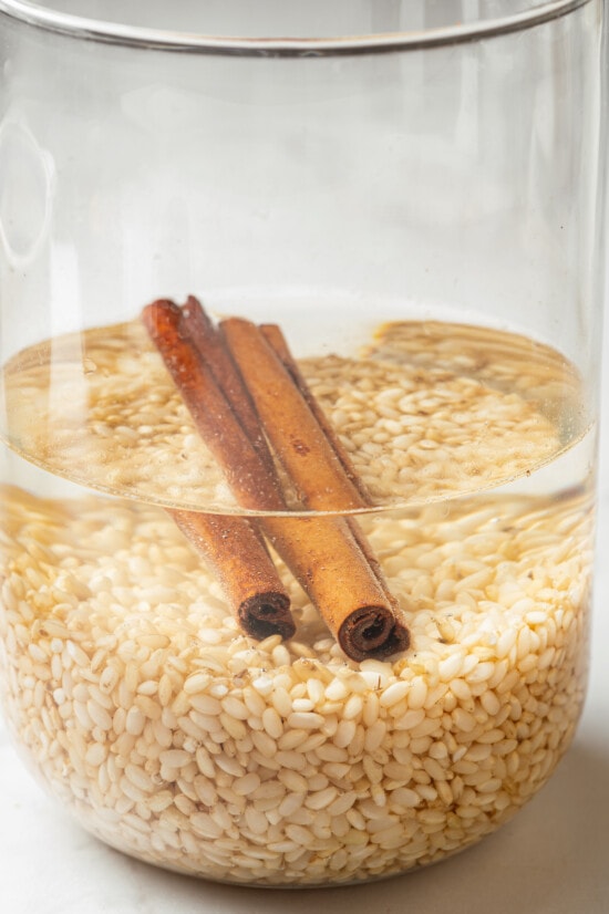 Made with brown rice, milk, sugar, and cinnamon served over ice, this Easy Horchata recipe makes a delightfully refreshing drink for hot days. Brown rice and cinnamon sticks soaking in water