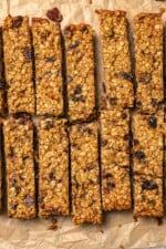 Sliced chewy granola bars on parchment paper.