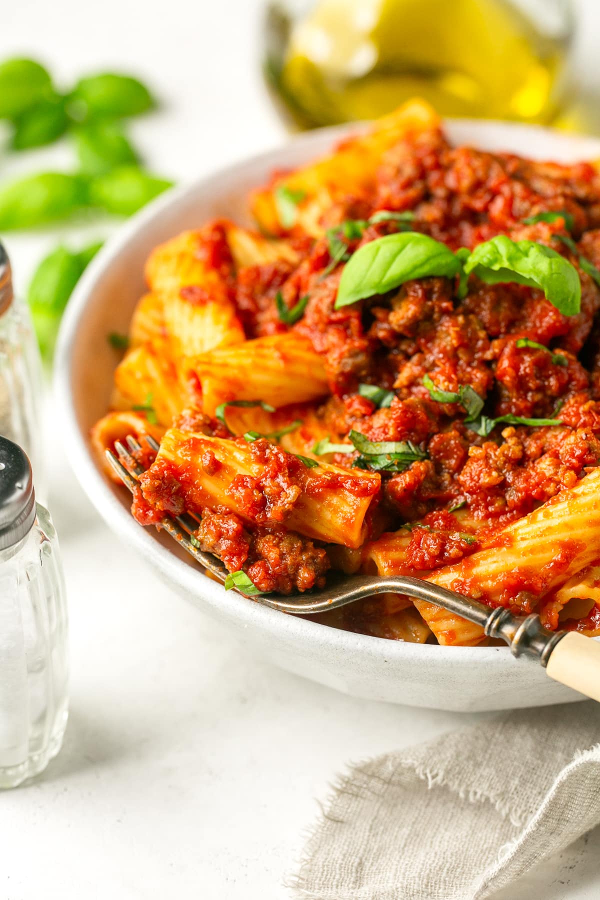 This easy, 5-ingredient sausage pasta sauce is made in the crock pot with flavorful chicken or turkey Italian sausage. Perfect for weeknights! A bowl with sausage pasta sauce served over rigatoni.