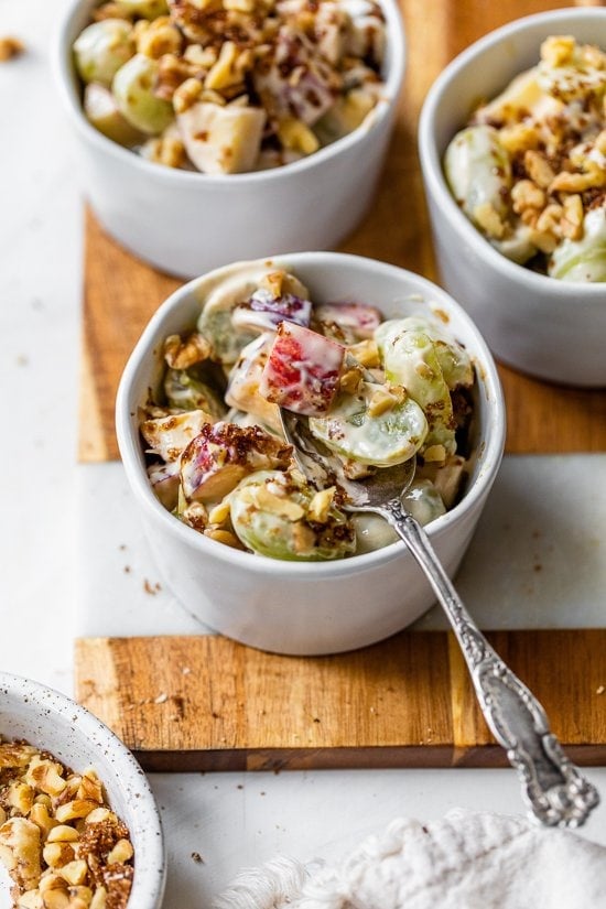 apple and grape fruit salad in a bowl with a spoon