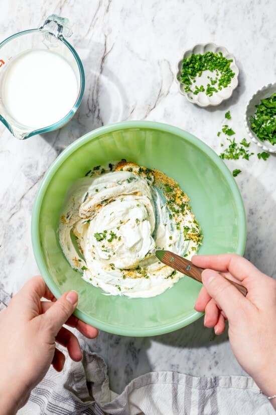 This lightened-up buttermilk ranch dressing is creamy, tangy, and full of fresh herbs. It’s an easy, lighter take on a classic favorite. Stirring together ingredients for buttermilk ranch dressing.