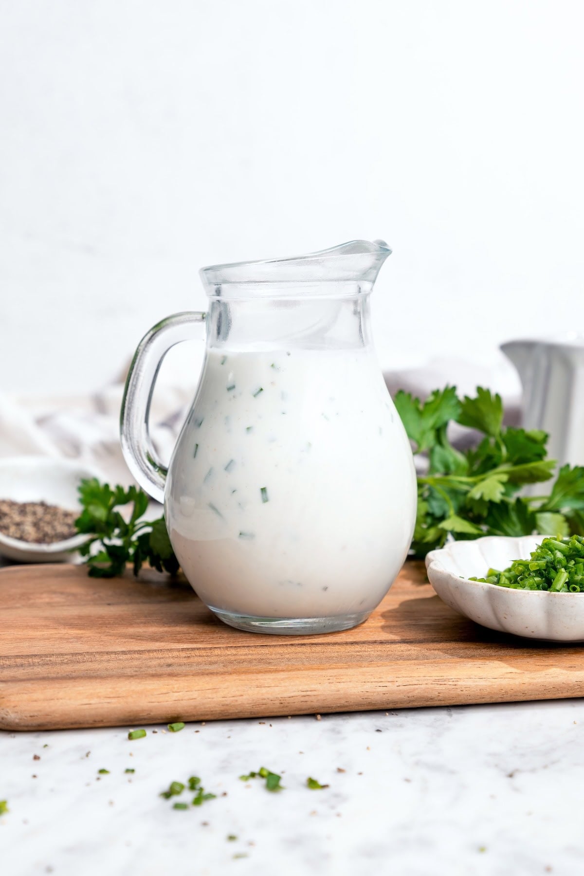 This lightened-up buttermilk ranch dressing is creamy, tangy, and full of fresh herbs. It’s an easy, lighter take on a classic favorite. Pitcher of buttermilk ranch dressing.