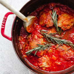 Pollo in Potacchio is an Italian braised chicken dish made with tomatoes, rosemary and garlic. The chicken cooks until it's fork tender, which is great served with pasta, noodles, spaghetti squash or polenta.