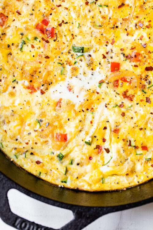 Caramelized onions and sautéed red bell peppers and zucchini mixed with eggs and Parmesan create a winning egg frittata breakfast dish.