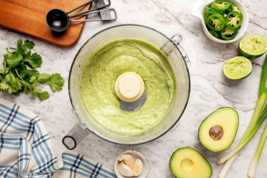 Creamy, bright, and tangy thanks to a buttermilk base, this avocado cilantro lime dressing is perfect for salads, tacos, and dipping veggies. Zesty avocado cilantro lime dressing in food processor bowl.