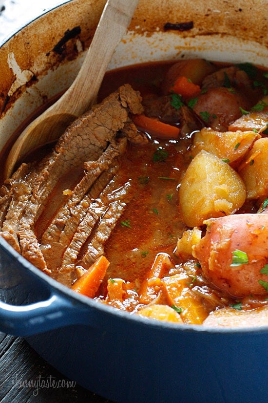 This braised brisket recipe is slow cooked in the oven with potatoes, carrots and onions. Slicing it half-way through makes it extra tender! Braised Brisket with Potatoes and Carrots in dutch oven.