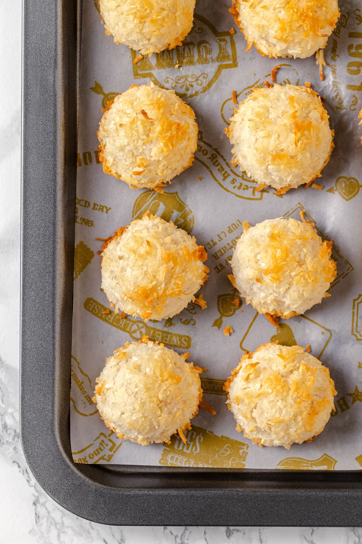 Made with sweetened coconut flakes, egg whites, and just a few other ingredients, Coconut Macaroons are moist, chewy, and perfectly flavored. Six coconut macaroons on a baking sheet