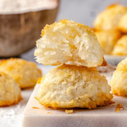 Two coconut macaroons stacked on each other, one showing the inside.
