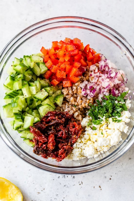 Farro , Feta, Cucumbers and Sun Dried Tomatoes in a bowl.