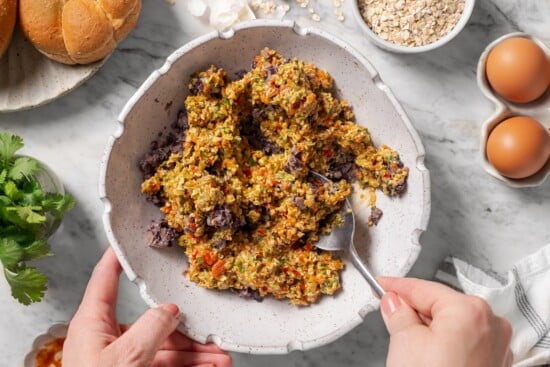 These black bean burgers are flavorful, satisfying and easy to make ahead. With a smoky chipotle mayo and avocado on top, they're delicious! Stirring binder into black bean mixture.