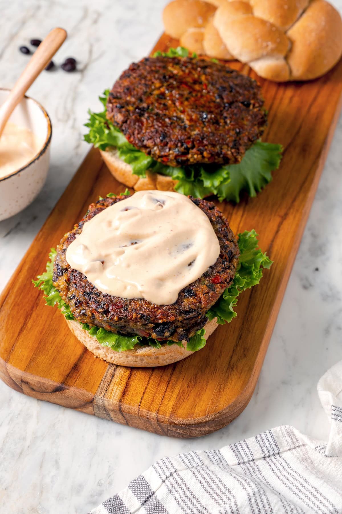 These black bean burgers are flavorful, satisfying and easy to make ahead. With a smoky chipotle mayo and avocado on top, they're delicious! Adding chipotle mayo to homemade black bean burgers.