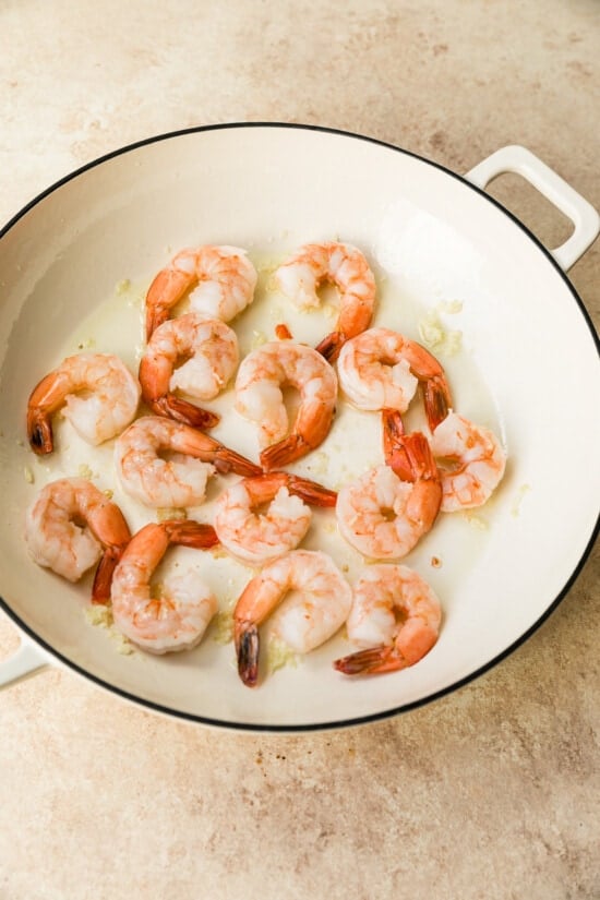 This easy homemade Pad Thai recipe is a lightened up version of the original made with shrimp, eggs, and tofu. Dinner’s done in 25 minutes! Shrimp cooking in wok