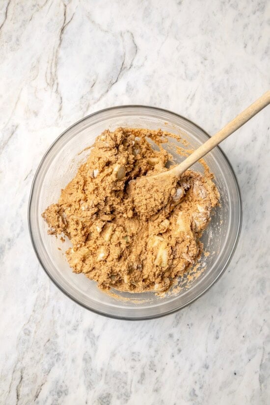 Buttermilk gives these spiced apple scones a moist, tender crumb, while applesauce replaces much of the butter to lighten them up! Overhead view of apple scone dough in glass bowl with wooden spoon