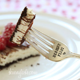 Cheesecake squares, lightened up with yogurt and light cream cheese, baked on a chocolate graham cracker crust drizzled with melted chocolate and topped with fresh raspberries.