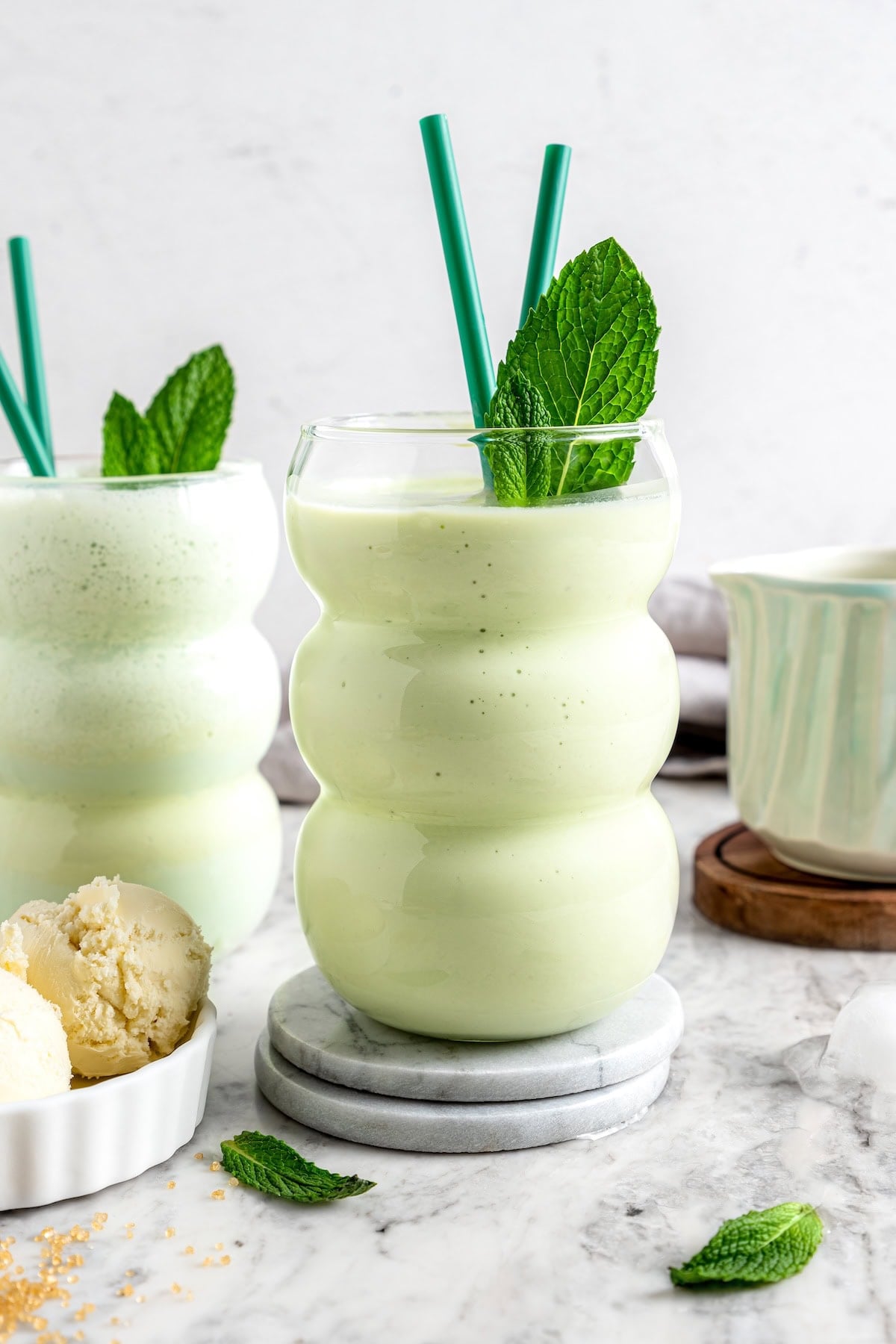 This easy homemade shamrock shake recipe is thick, creamy, and minty just like the original—with a fraction of the calories! Skinny shamrock shakes in glasses with straws and fresh mint leaves