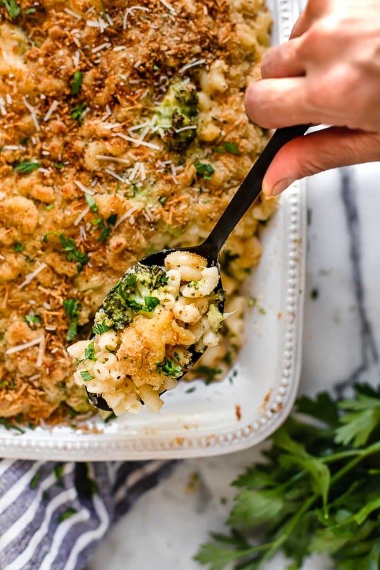Creamy, cheesy, and packed with veggies, this lightened-up broccoli mac and cheese delivers kid-friendly comfort without feeling too heavy. Spoonful of broccoli mac and cheese held over baking dish.