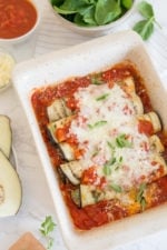 Overhead view of baked eggplant rollatini in a baking dish.