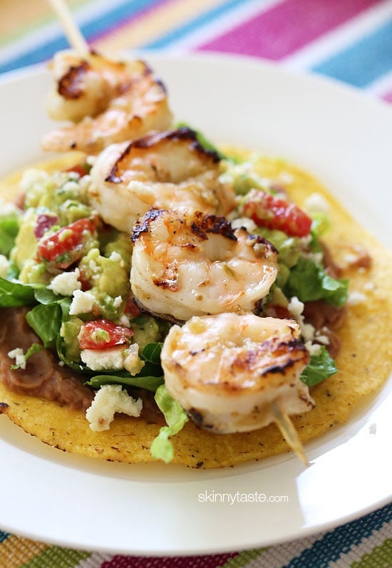 Grilled Shrimp Tostadas Grilled Shrimp Tostadas are SO good, layered with homemade guacamole, refried beans and lettuce on top of a crispy tostada.