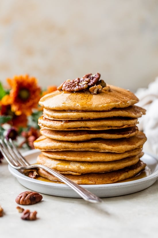 Made with whole wheat flour, pumpkin puree, pumpkin spice, and pecans, these Pumpkin Pancakes are soft, fluffy, and filled with fall flavor. A stack of Whole Wheat Pumpkin Pecan Pancakes with syrup