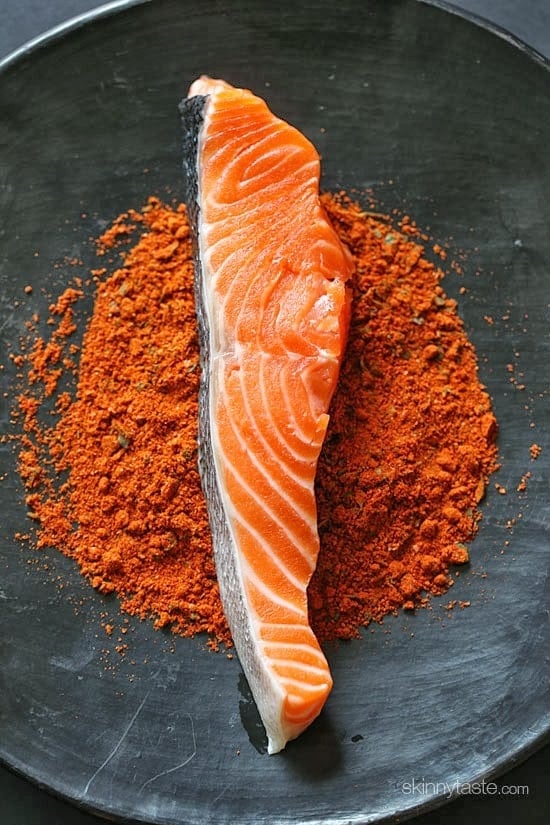 A salmon fillet in a bowl of spices