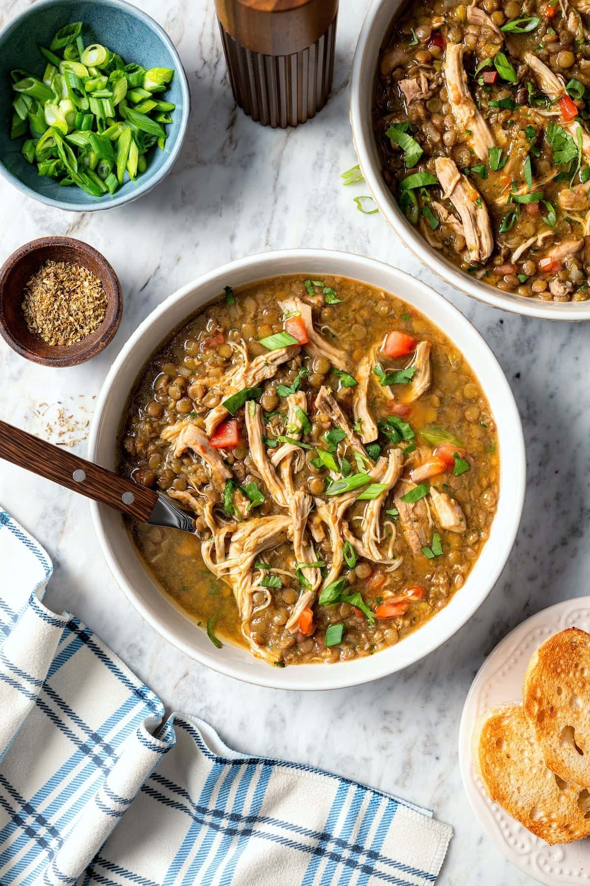 This chicken lentil soup is hearty, flavorful, and easy to make. It’s a nourishing, protein-packed meal perfect for cold days. Two bowls of chicken lentil soup with cilantro.