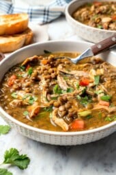 Bowl of chicken lentil soup with spoon.