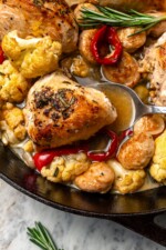 Spoon scooping chicken scarpariello from pan.