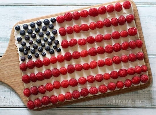 Red, White and Blue fruit "pizza" is more like a cookie bar, topped with cream cheese frosting and fruit – The perfect 4th of July dessert!
