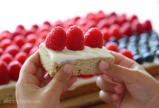 Red, White and Blue fruit "pizza" is more like a cookie bar, topped with cream cheese frosting and fruit – The perfect 4th of July dessert!