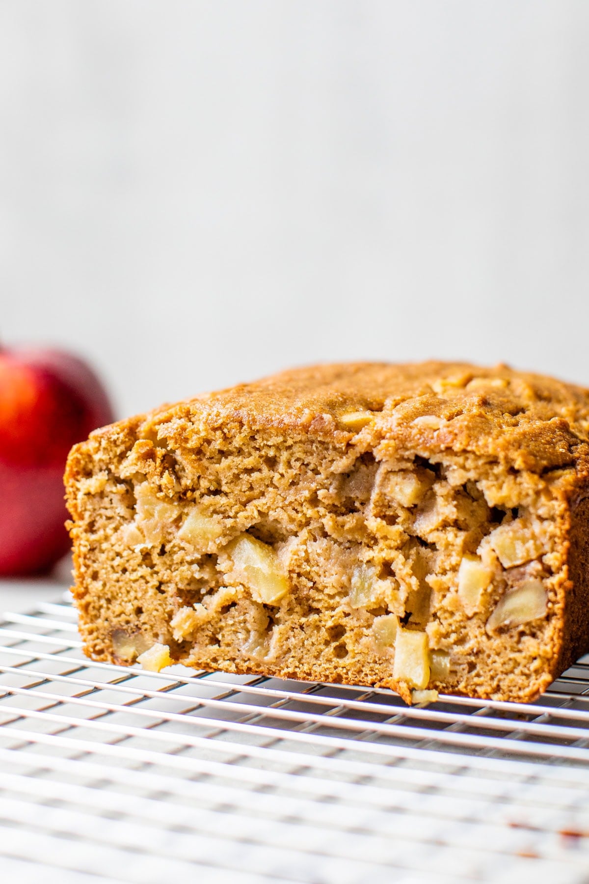 Moist apple bread recipe made with homemade applesauce, fresh apple chunks, spices, and walnuts in every bite. It's easy and so delicious! Apple bread on a wire rack.