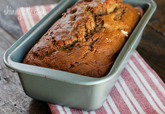 Moist apple bread recipe made with homemade applesauce, fresh apple chunks, spices, and walnuts in every bite. It's easy and so delicious! A baked apple bread loaf in a loaf pan.
